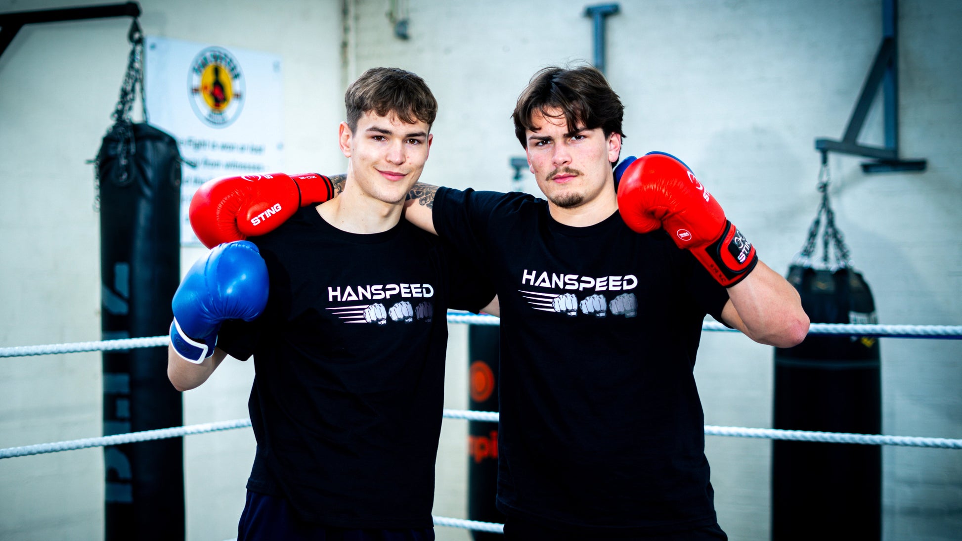 Two individuals in a boxing ring wearing Hanspeed boxing gear.